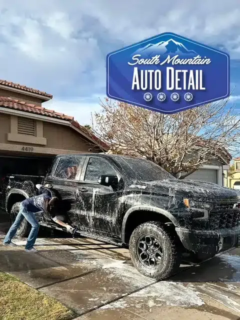 HBHF Detailing technician pressure washing black truck at Grand Island AZ driveway